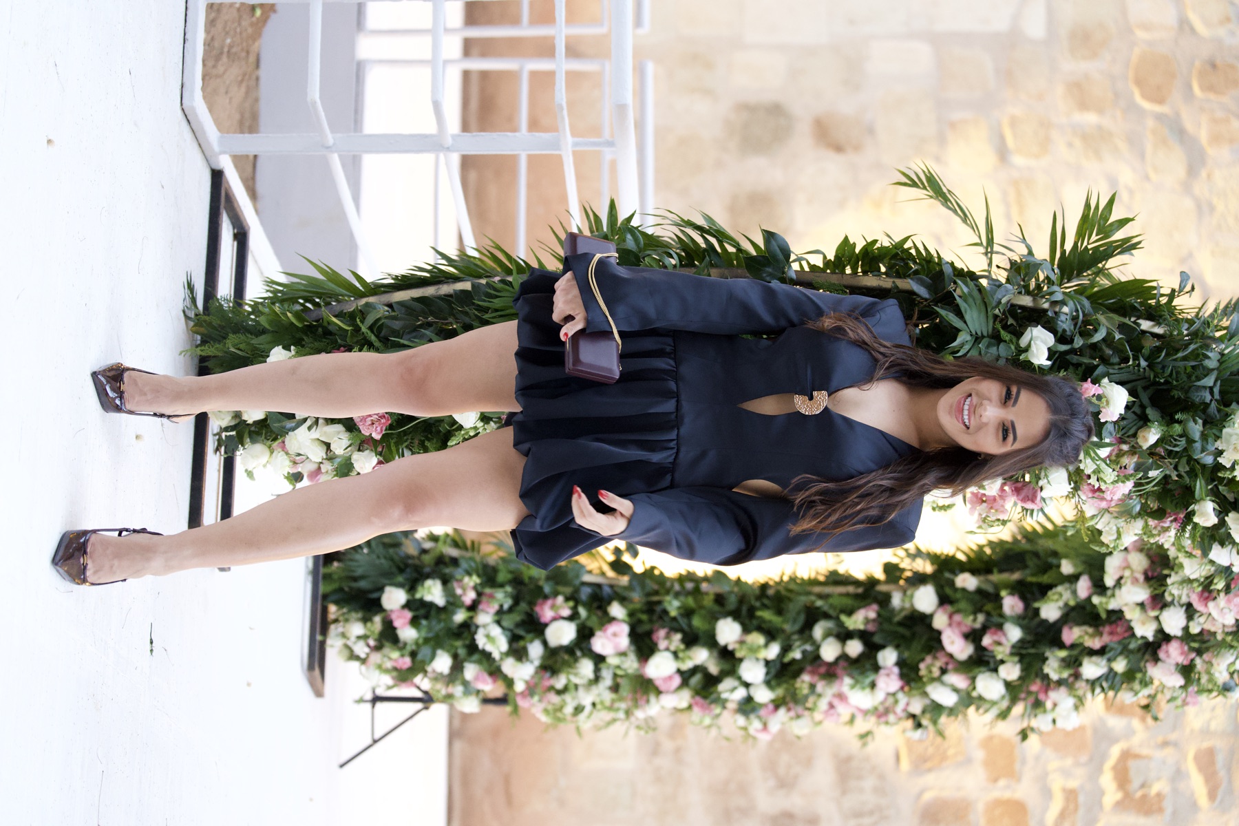 Retrato editorial de invitada frente a arreglo floral