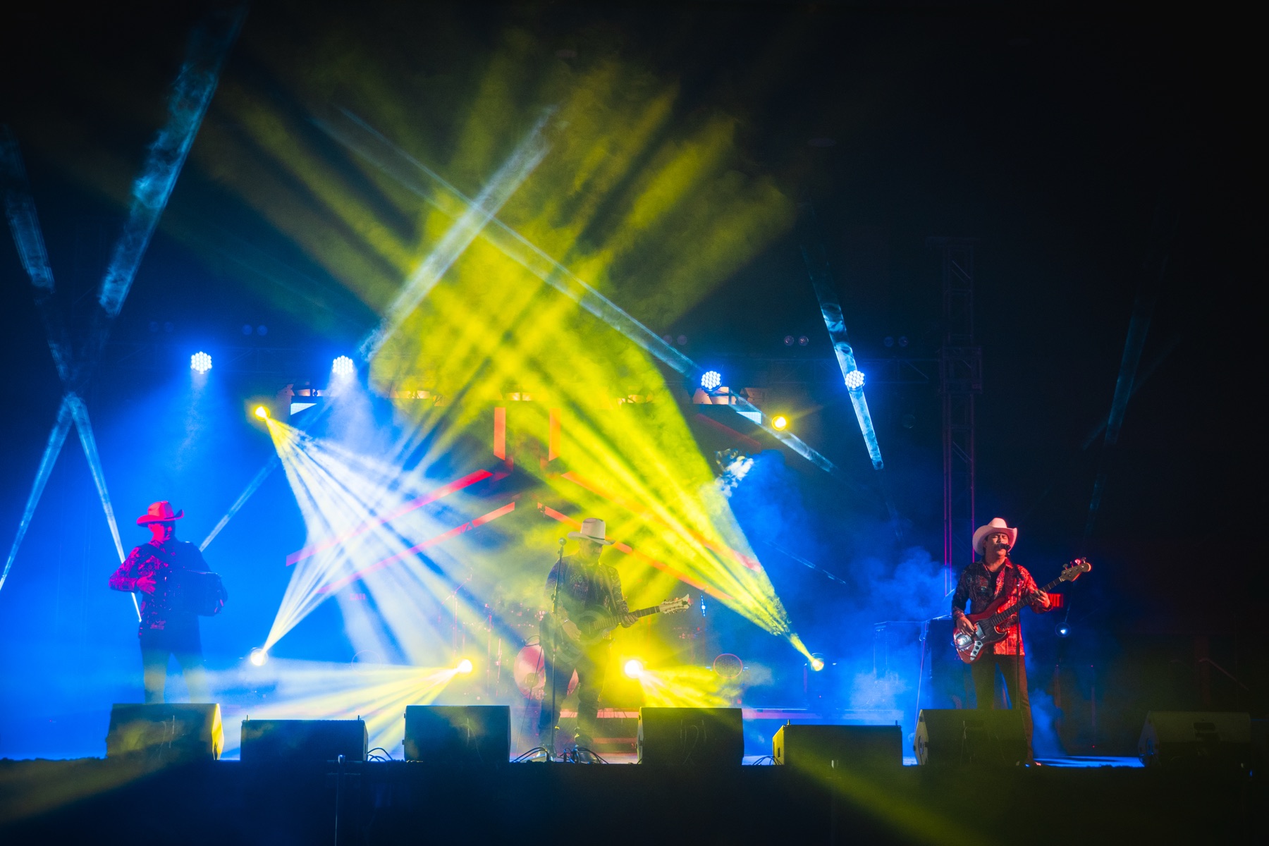 Escenario musical amplio con haces de luz amarillos y azules